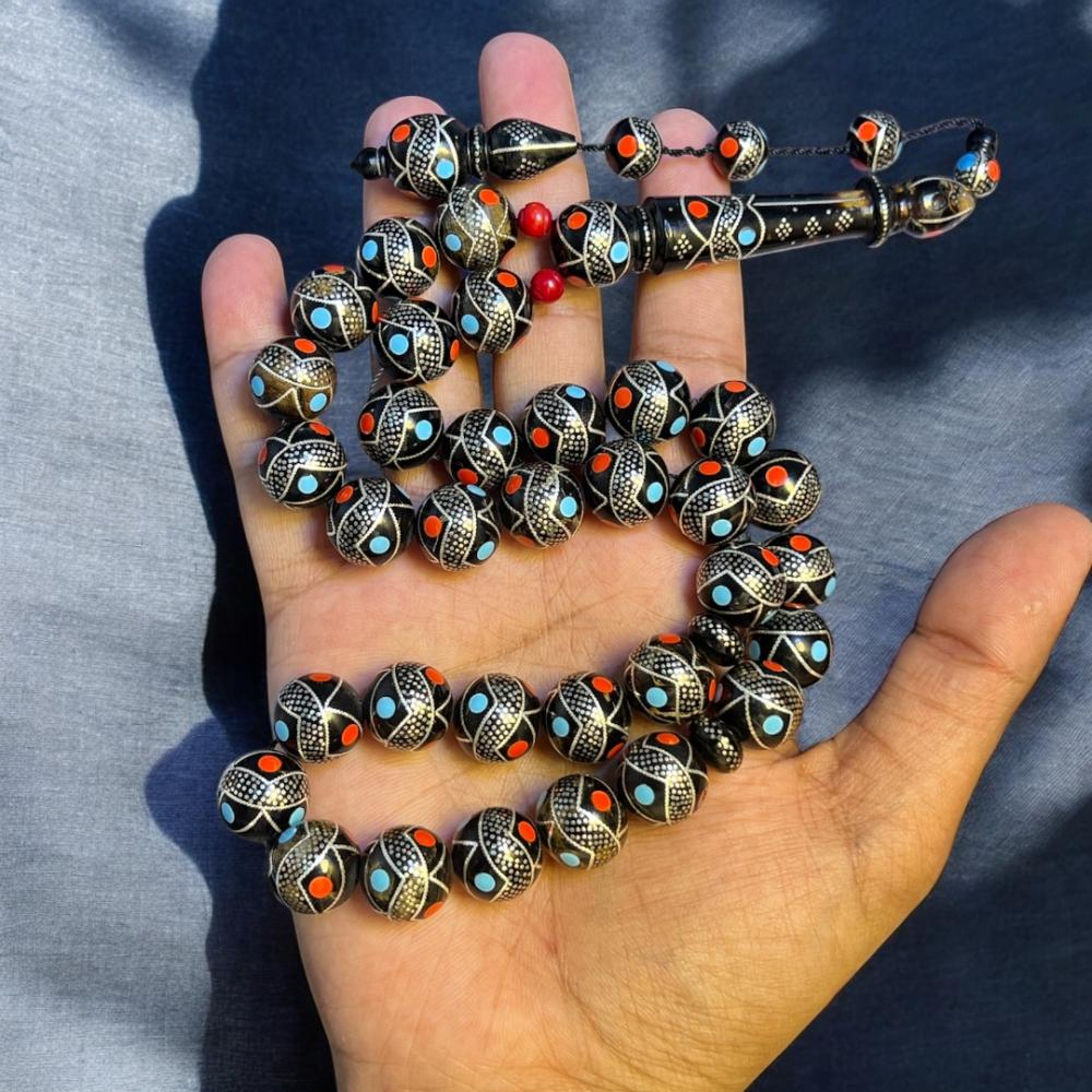 هذه مسبحة فضية مرصعة بالفيروز الأزرق والمرجان الأحمر.